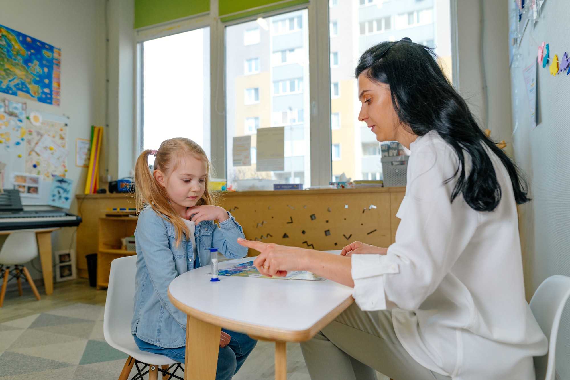 Teacher spreads out puzzle in front of the child